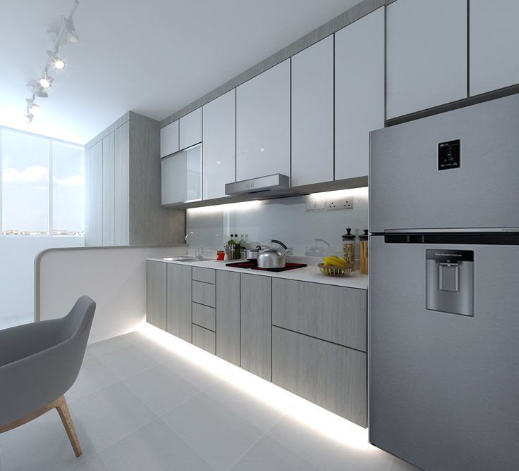 a modern kitchen with stainless steel appliances and white countertops, along with a gray chair