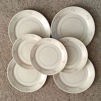 a pile of white plates sitting on top of a carpeted floor next to each other