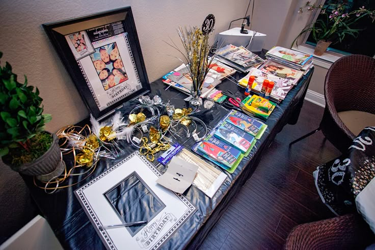 the table is covered with various items and decorations for an event or party, as well as pictures