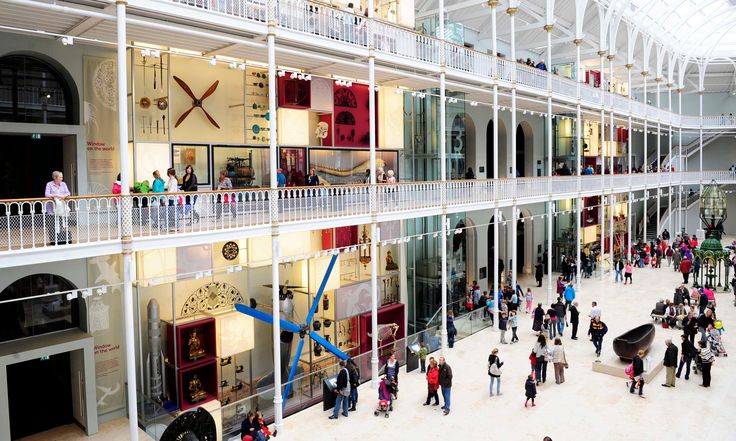 an indoor mall with people walking around and onlookers