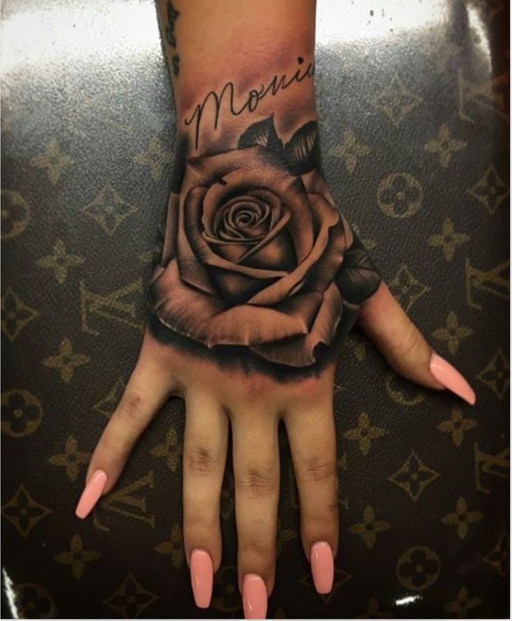 a person's hand with a rose tattooed on it