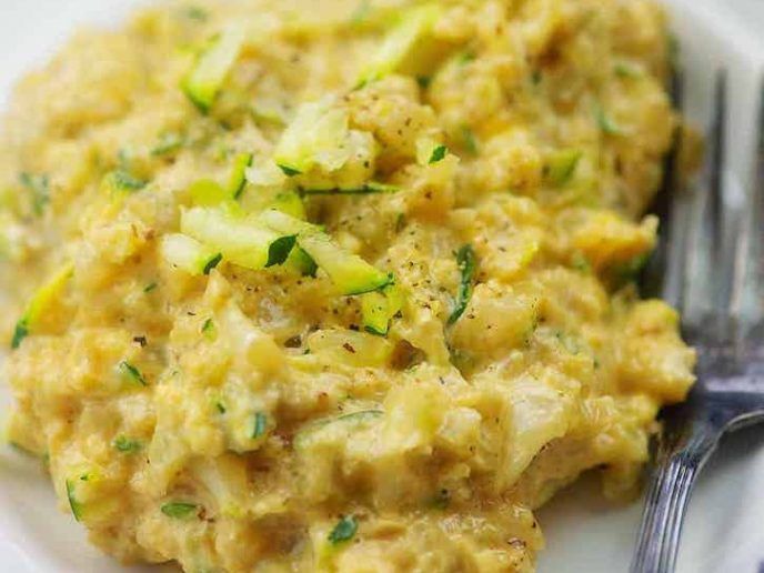 a white plate topped with mashed potatoes and cucumbers next to a fork