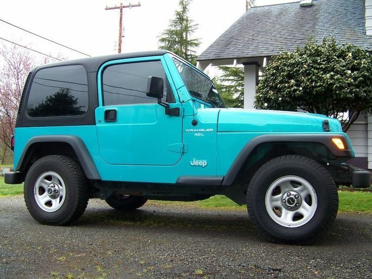 a blue jeep parked in front of a house