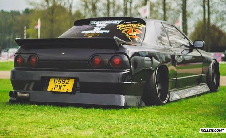 a black car parked on top of a lush green field