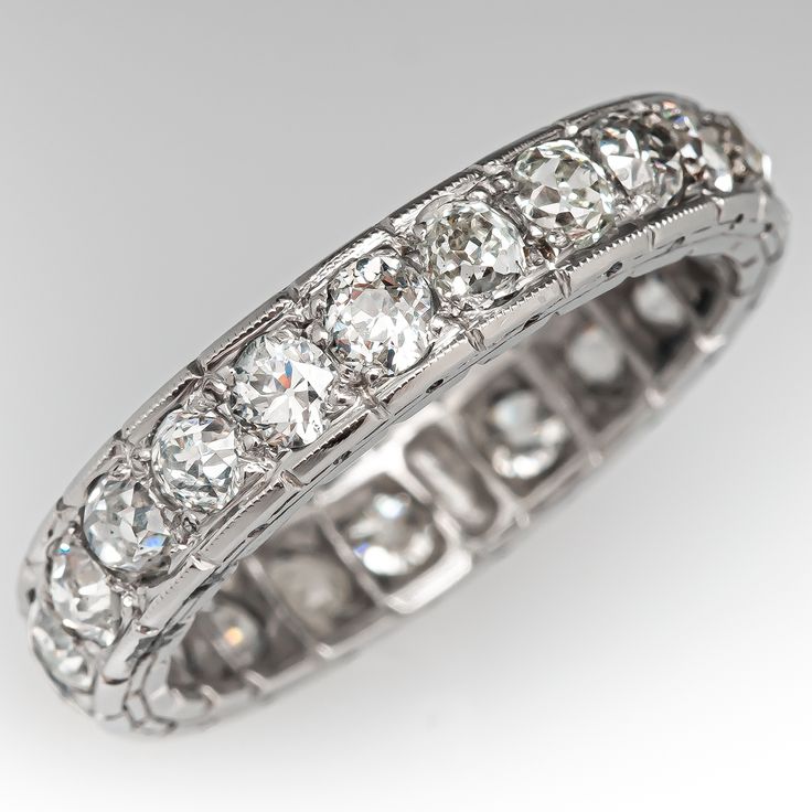 This elegant circa 1930s eternity band is accented with twenty-two (22), bead set, old European cut diamonds and bordered with milgrain edging. The band measures 4.7mm wide and 2.5mm thick. This ring is a size 8.75 and cannot be resized due to the design. Three of the diamonds have chips. Classic Eternity Band With Decorative Band For Anniversary, Classic Eternity Band For Anniversary, Round Diamond Eternity Band With Decorative Design, Classic Eternity Wedding Band, Vintage Platinum Jewelry With Diamond Accents, Heirloom Diamond Eternity Band With Diamond Cut, Heirloom Eternity Band With Brilliant Cut, Classic Platinum Eternity Band With Single Cut Diamonds, Classic Diamond Eternity Band With Decorative Design