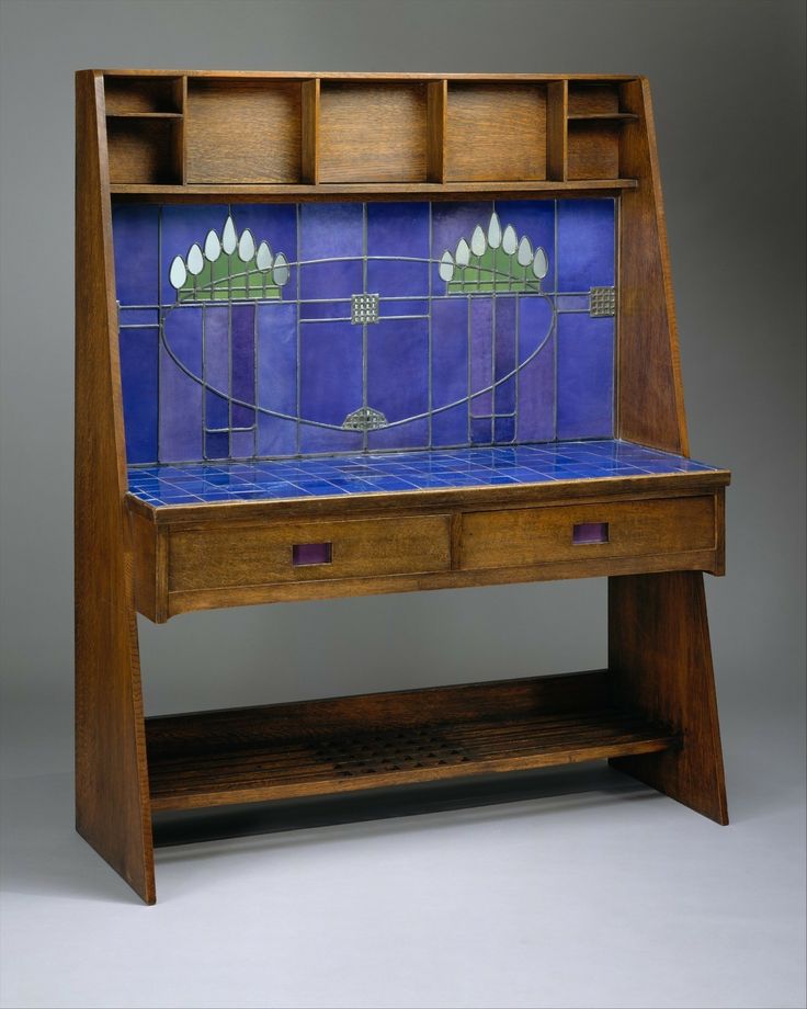 a wooden desk with blue tiles on the top and bottom shelf, in front of a gray background