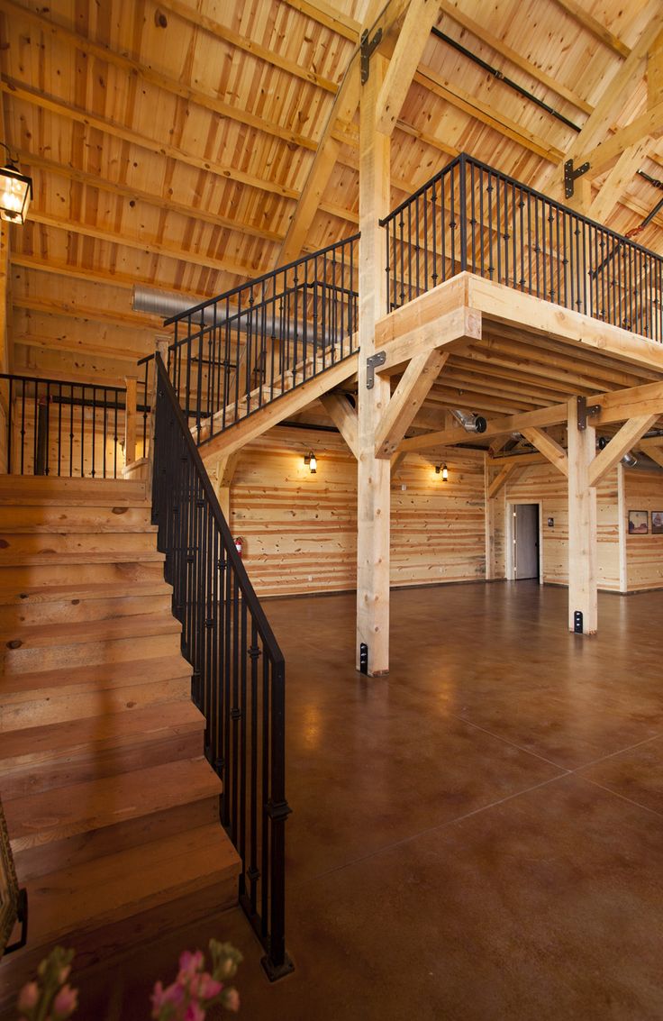 the inside of a large building with wooden walls and stairs leading up to an upper level