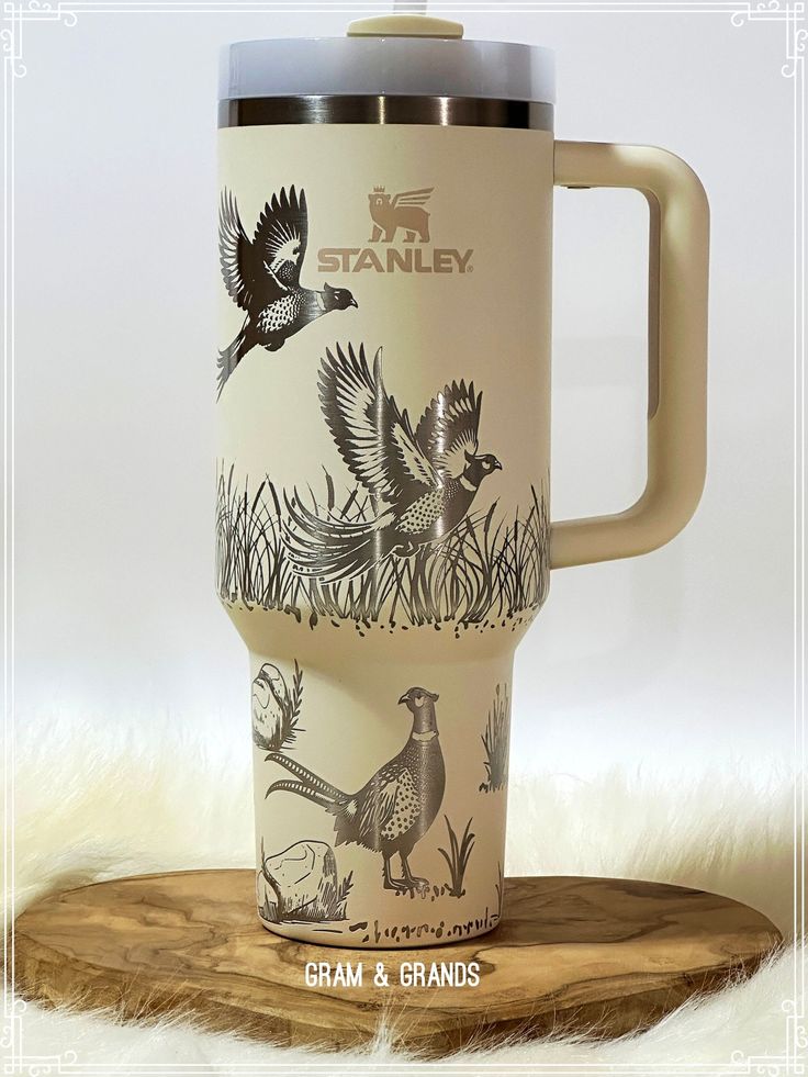 an image of a coffee cup with birds on it and the words stanley printed on it