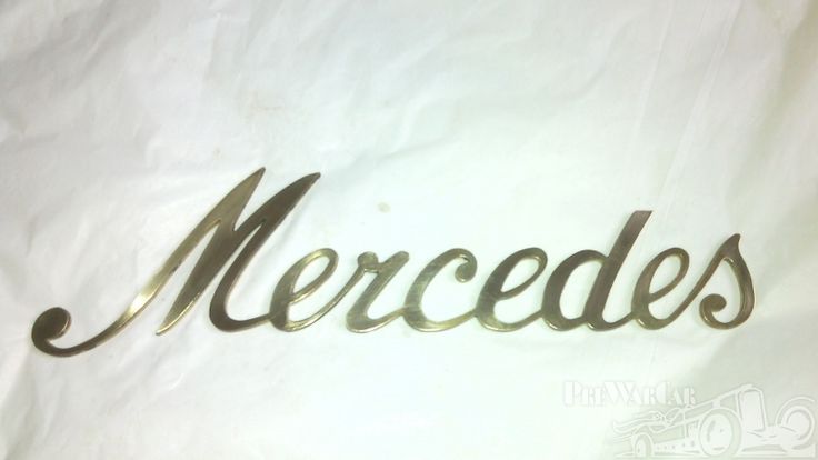 the word mercedes written in cursive metal letters on a white sheet