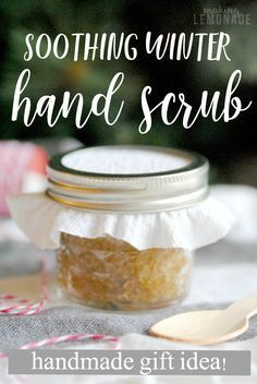 a jar filled with hand scrubs sitting on top of a table next to a spoon