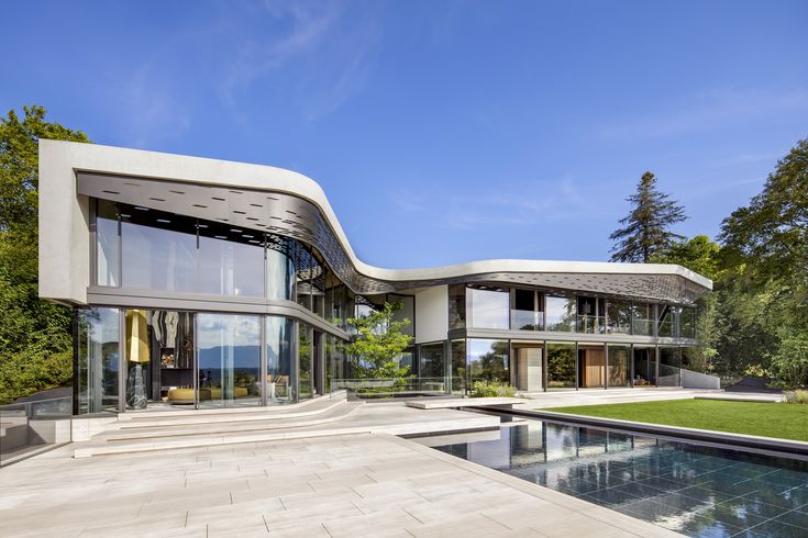 a large house with a pool in front of it and lots of windows on the side