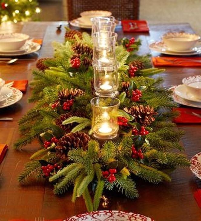 the table is set for christmas dinner with pine cones and candles