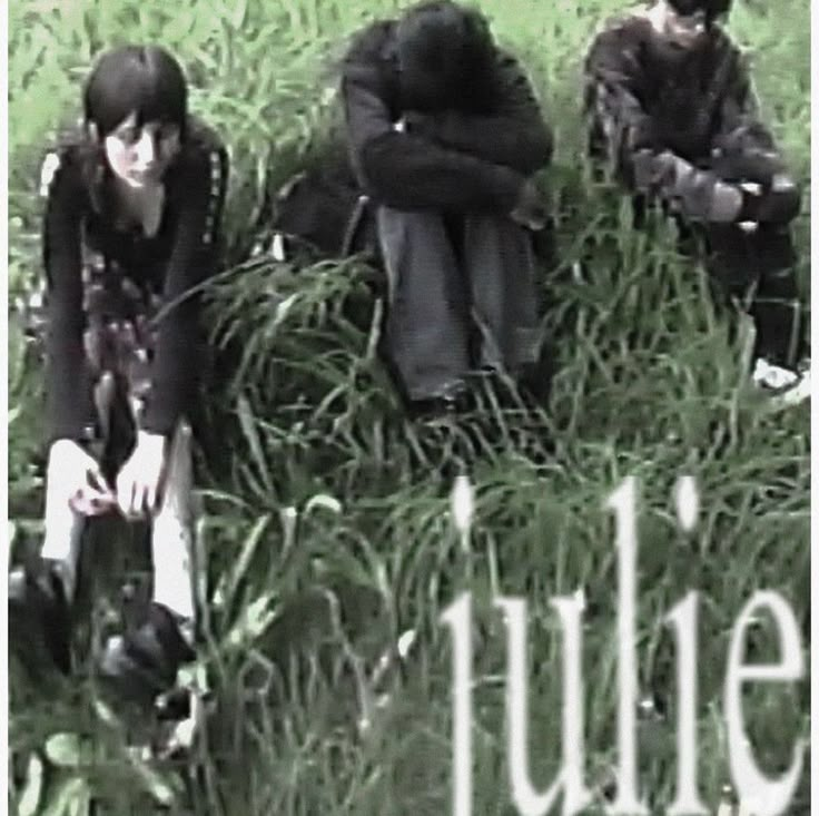 three people sitting in tall grass with the words julia on it's front and back