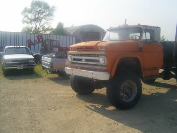 an orange truck parked next to other trucks