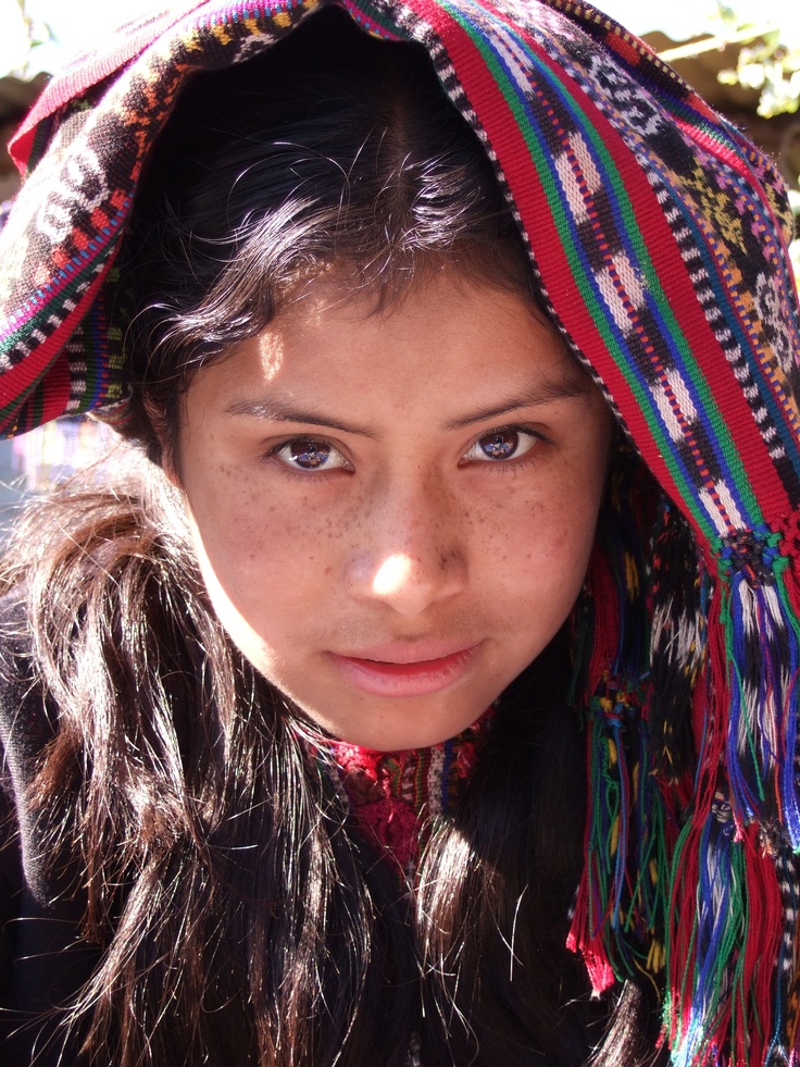 a young woman with freckled hair wearing a colorful headdress and scarf