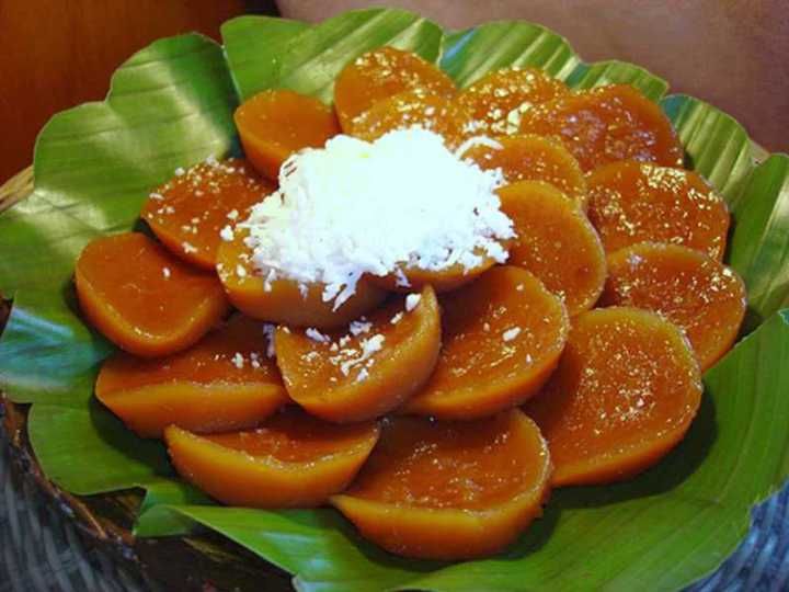 a green plate topped with sliced oranges and powdered sugar on top of it