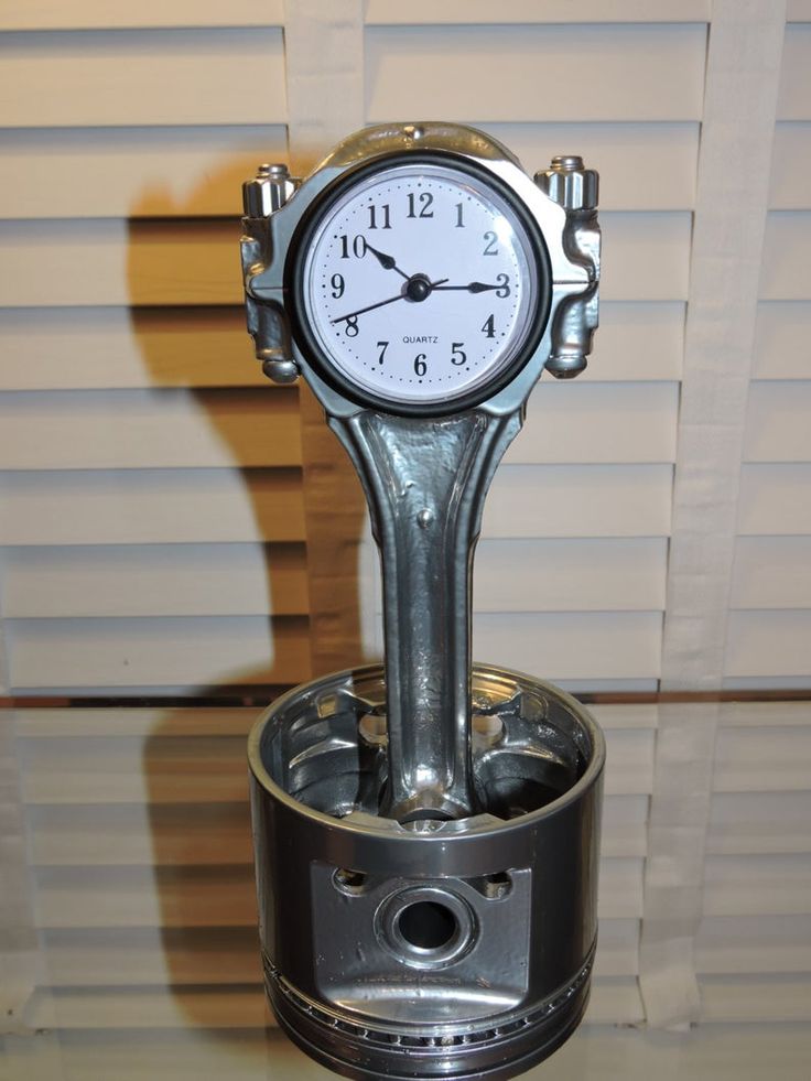 a clock sitting on top of a metal object in the shape of a canister