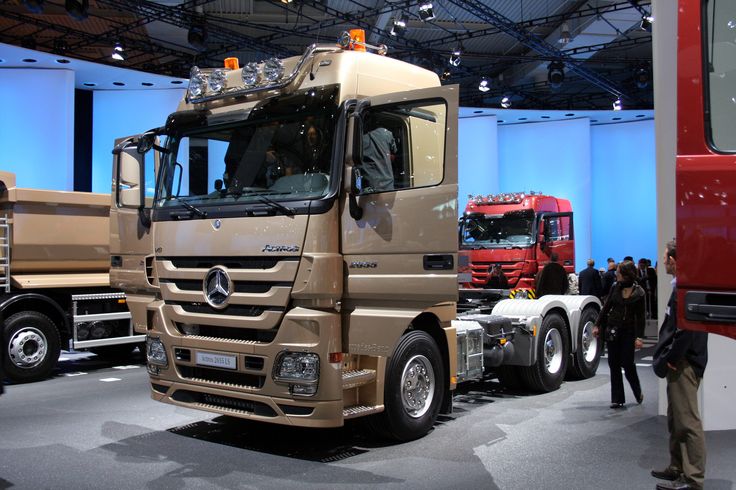 people are looking at trucks on display in a showroom