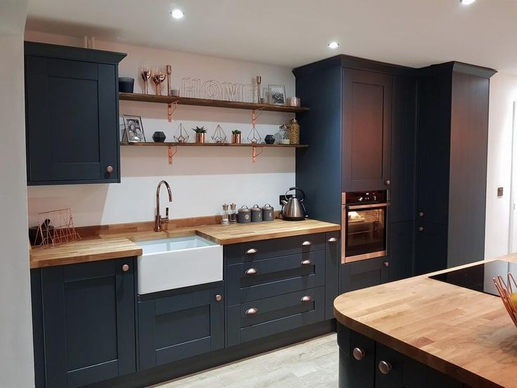 a kitchen with wooden counter tops and blue cabinets