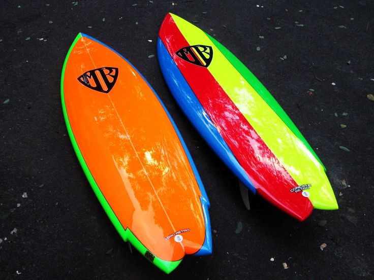 two surfboards sitting side by side on the ground