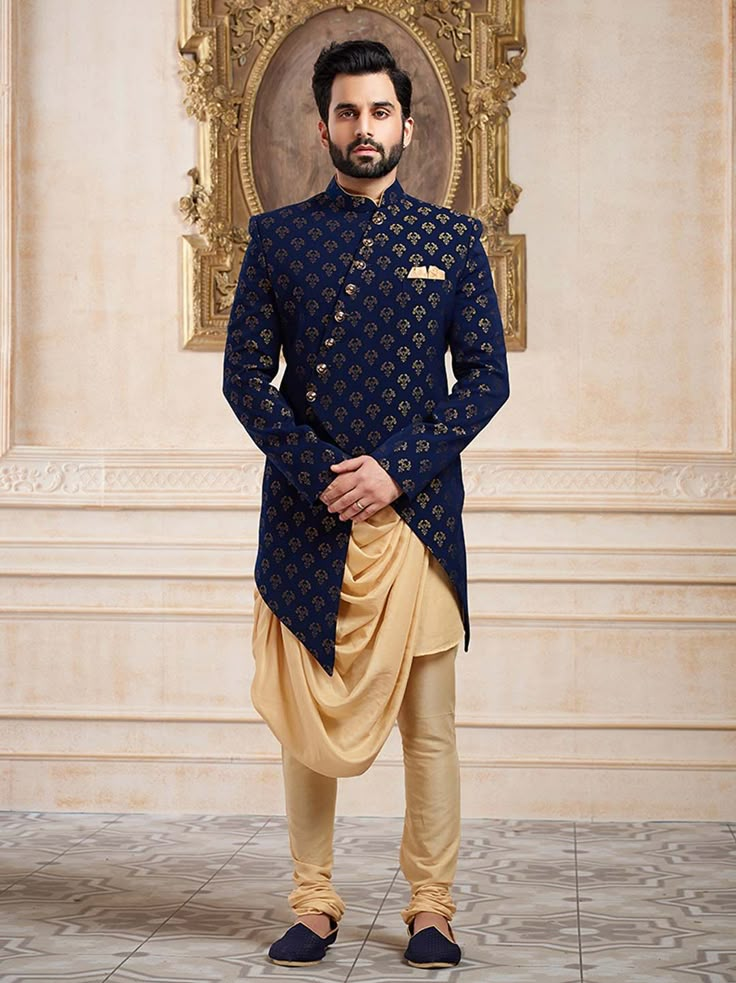 a man standing in front of a wall wearing a blue and gold outfit