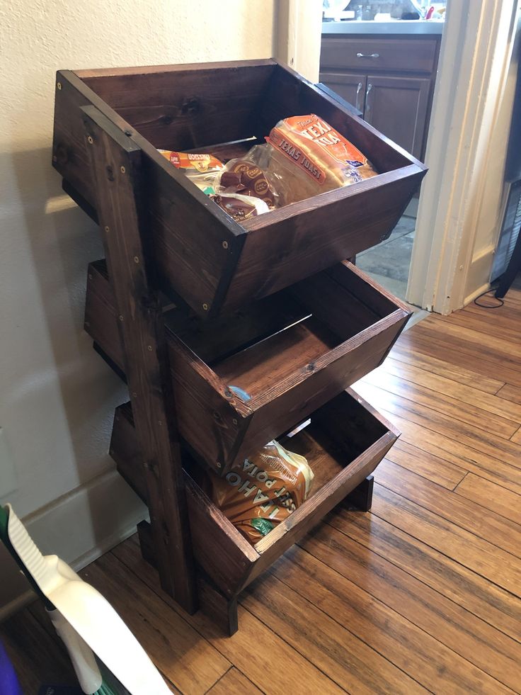 a wooden crate filled with food sitting on top of a hard wood floor