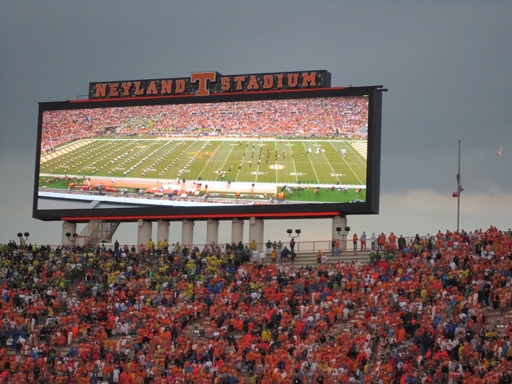 a football stadium filled with fans watching a game on the big screen television in front of an audience