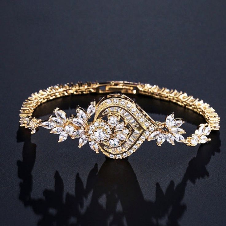 A classy bracelet in art deco vintage inspired style. Featuring intricately faceted cubic zirconia that catch the light from every angle, the bracelet is rhodium / rose gold / yellow gold plated for a flawless finish which perfectly enhances the intricate detailing and conveys a modern take on old elegance. Length: 7" (approx. 18cm); Width: 1" (approx. 2.6cm). Closure is a secure fold-over clasp. Weight: 14g.Choose between Silver, Rose Gold and Yellow Gold finishes. To make your choice select yo Glamorous Cubic Zirconia Crystal Bracelet Gift, Elegant Sparkling Stones Tennis Bracelet For Party, Elegant Tennis Bracelet With Sparkling Stones For Party, Elegant Party Tennis Bracelet With Sparkling Stones, Elegant Sparkling Tennis Bracelet For Parties, Elegant Crystal Chain Bracelet For Gift, Elegant Diamond White Crystal Bracelet For Party, Elegant Diamond Accented Tennis Bracelet For Party, Elegant Diamond Bracelet With Sparkling Stones For Anniversary