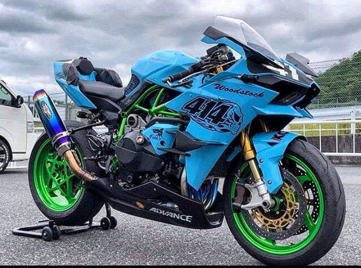 a blue and green motorcycle parked in a parking lot