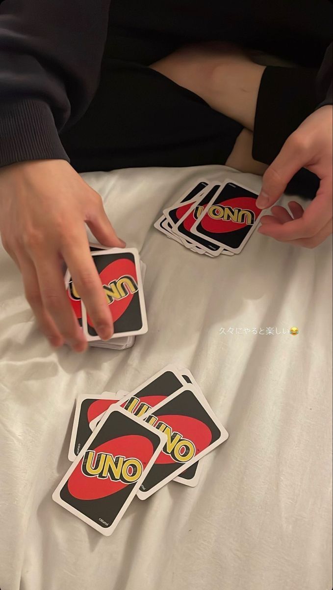 someone is playing uno uno on the bed