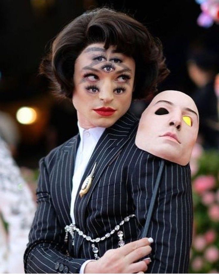 two people dressed in costumes with makeup on their faces and one holding the other's head