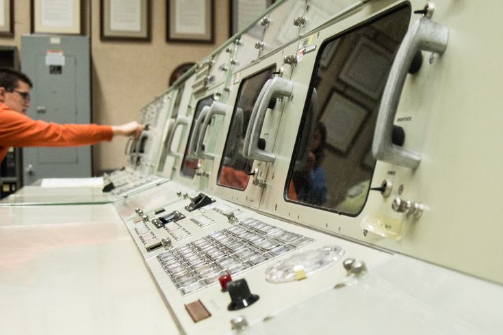 a man standing next to a row of washers in a room filled with machines