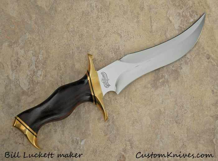 a knife that is laying on top of a rock with gold trimmings and a black blade