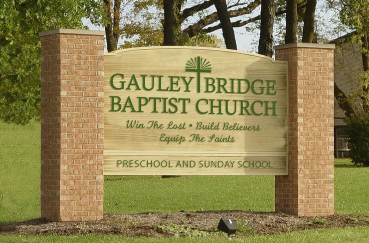 the sign for gauley bridge baptist church in front of some trees and grass