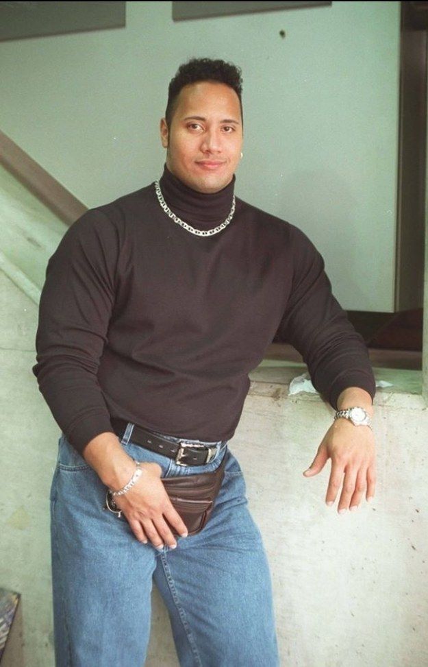 a man in jeans and a black shirt is posing for the camera with his hands on his hips