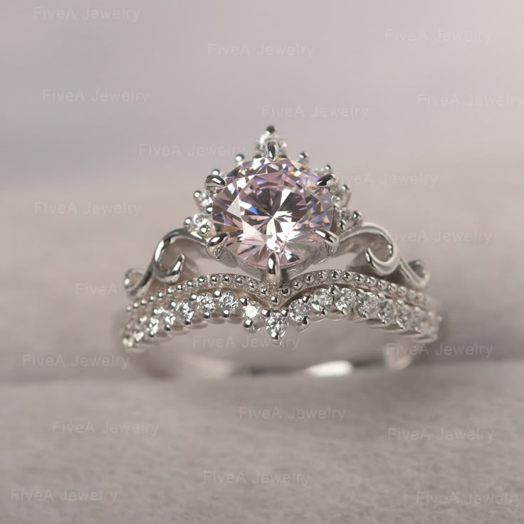 a white gold engagement ring with a center stone surrounded by smaller round brilliant cut diamonds