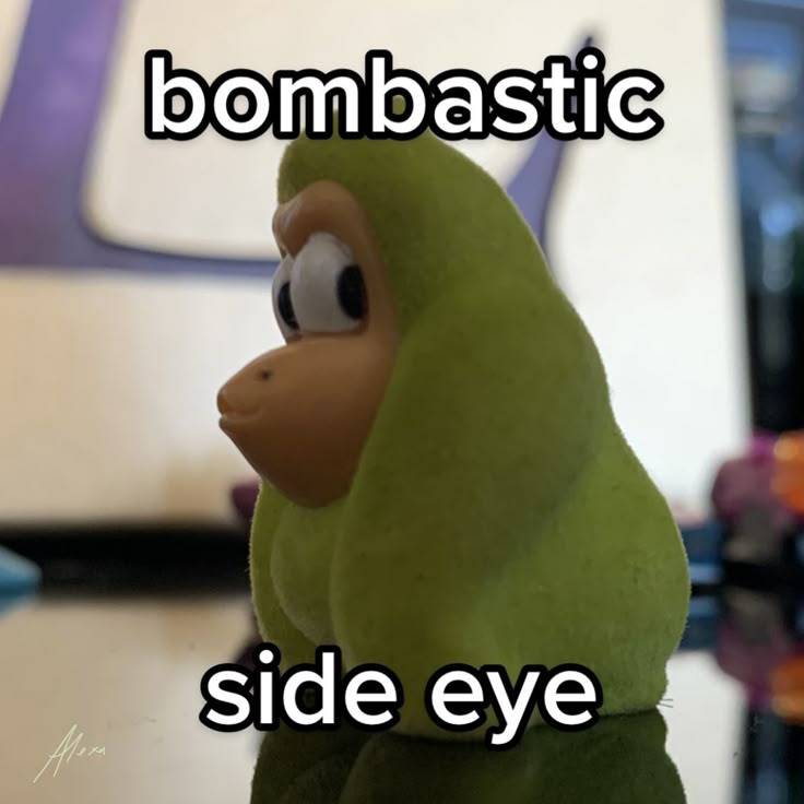 a close up of a stuffed animal on a table with the words bombbastic side eye