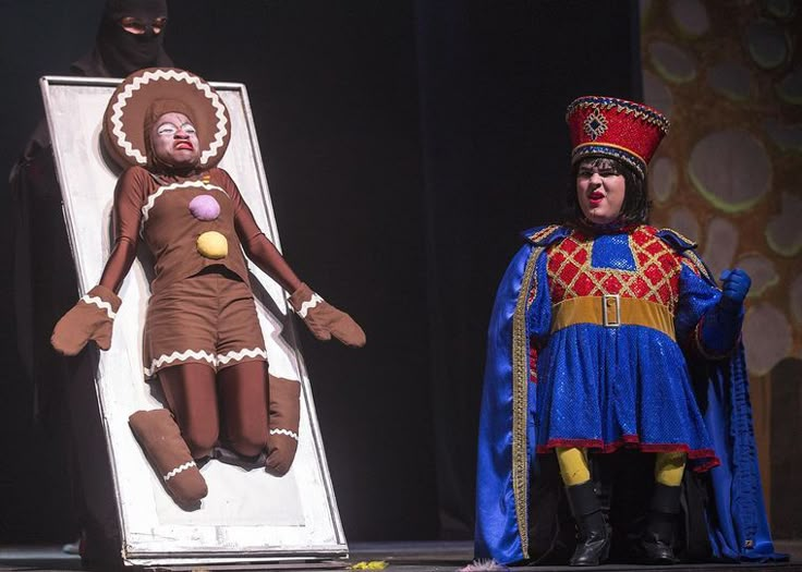 two people in costumes on stage one is dressed as a man and the other is wearing a costume