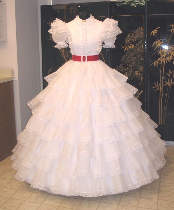 Scarlett O'Hara (Alternate) White Ruffles & Lace Dress.  This gown is constructed of 33 yards of 100% USA cotton organdy. It has 135 + yards of lace applied to the 8 tier skirt, as well as the front and back bodice insets and 4 bodice ruffles.  32 ball buttons trim the front. (reproduction by Gwtw4eveR) Gone With The Wind Dresses, Southern Belle Dress, Antique Dress, Beautiful Costumes, Antique Clothing, Gone With The Wind, Tier Skirt, Steampunk Fashion, Vintage Beauty