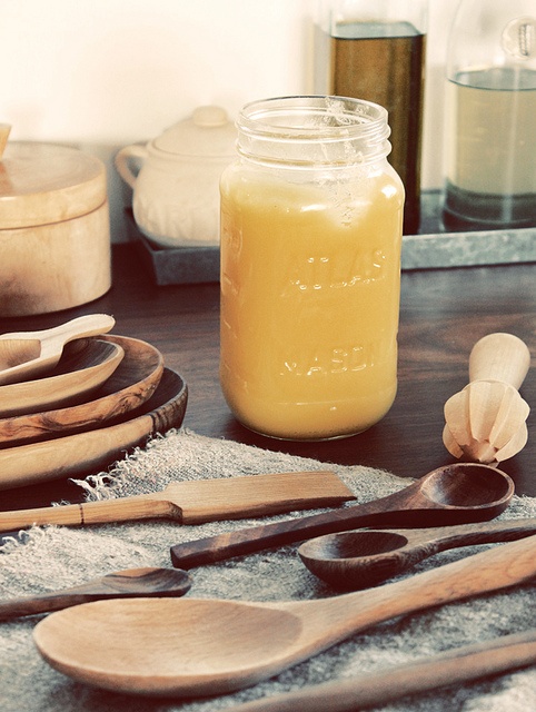 wooden spoons and jars on a table with utensils