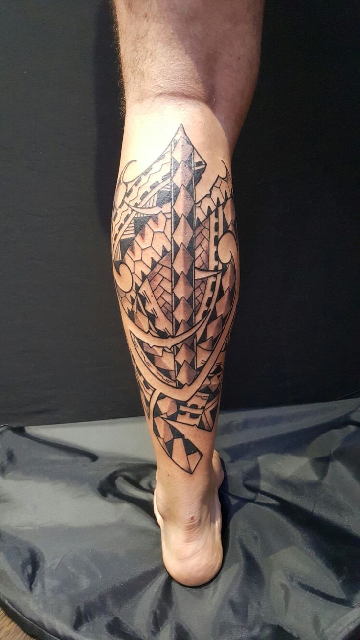 a man's leg with tattoos on it