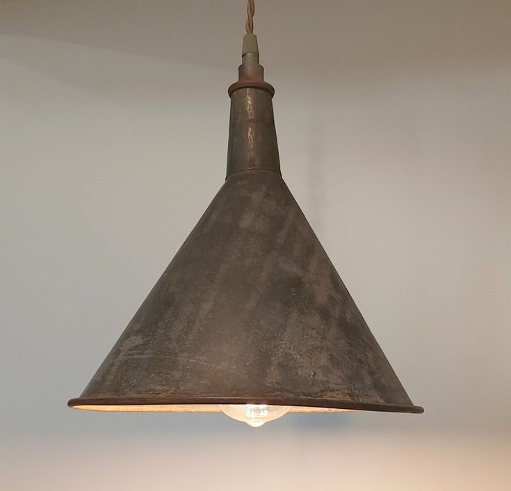 a light that is hanging from the ceiling in a room with a white wall behind it