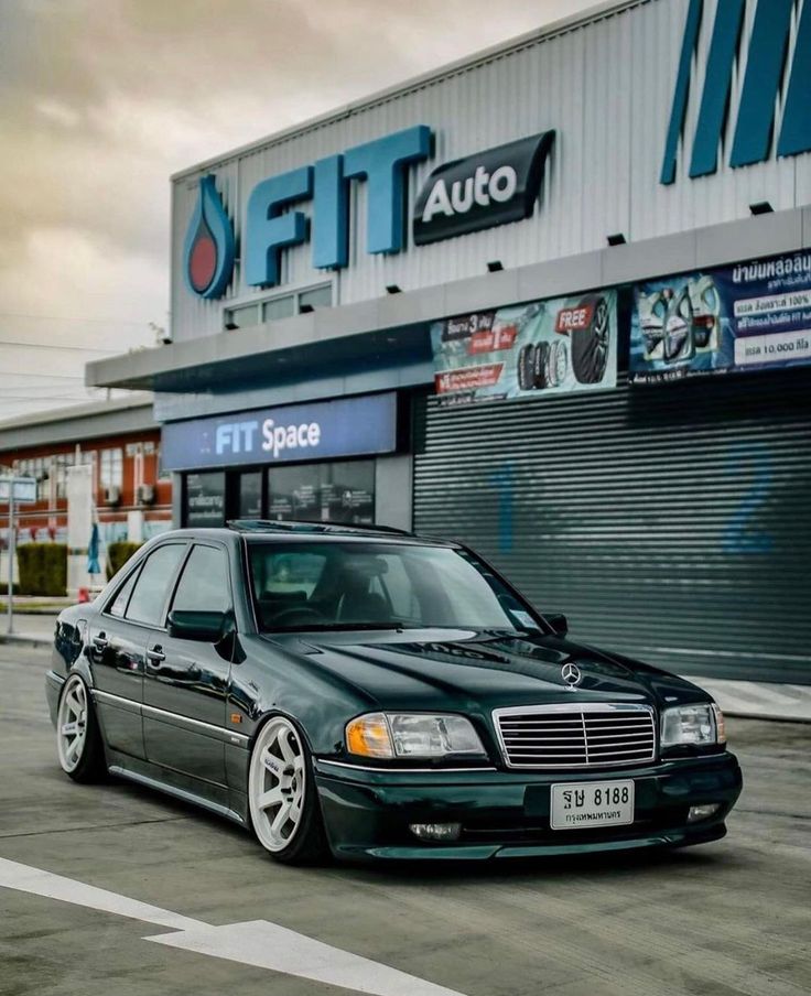 a black mercedes parked in front of a building