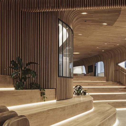 the interior of an office building with wooden walls and stairs leading up to two levels