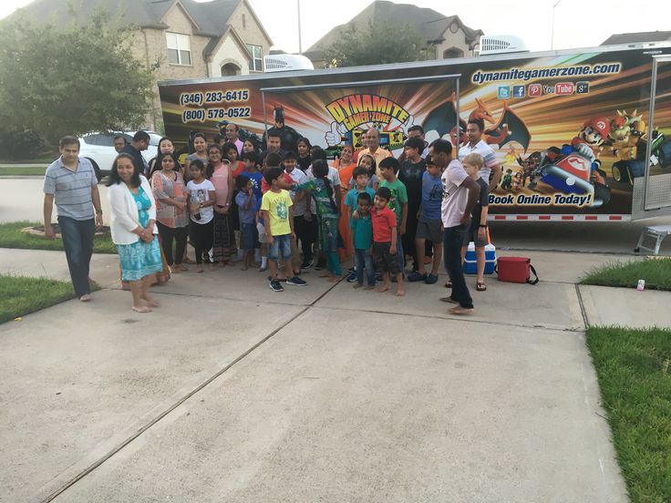 a group of children standing in front of a food truck with an advertisement on the side