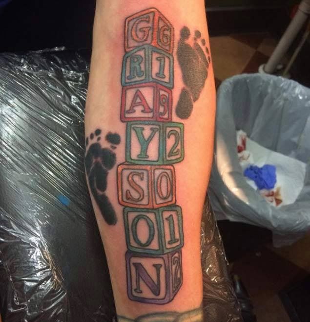 a person with a tattoo on their arm that says baby born and son in blocks