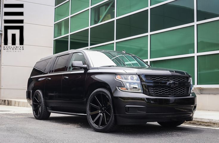 a black suv parked in front of a building