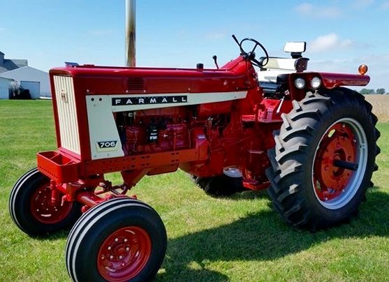 an old farmall tractor parked in the grass