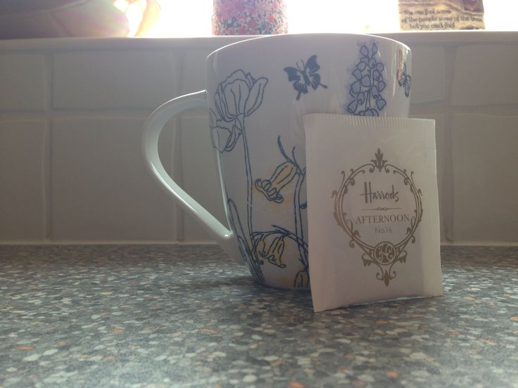 two coffee mugs sitting on top of a counter next to each other with a bag in front of them