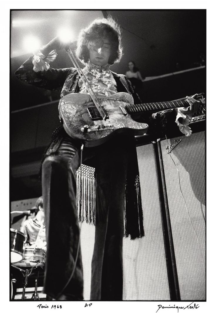 a black and white photo of a man playing an electric guitar